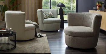 Drei moderne runde Sessel mit Boucle Stoff in den Farben Mint, Steingrau und Grün in einem modern eingerichteten Raum.