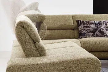 Grünes Sofa mit aufstellbaren Kopfstützen.