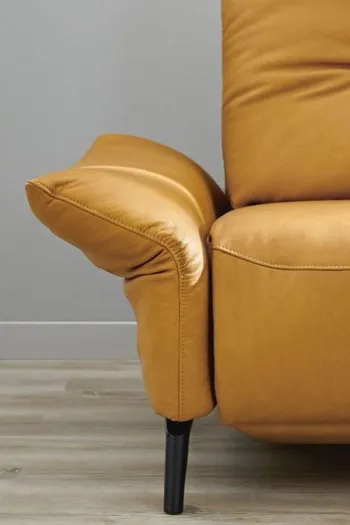 Linker Teil eines gelben Ledersofas bei dem die Armlehne nach außen geklappt ist mit schwarzem Fußgestell.