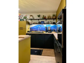 Gesamtansicht einer Küche mit onyxschwarzen Unterschränken und olivgrünen Oberschränken