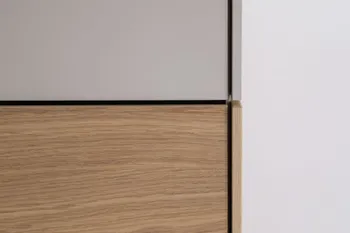 Nahansicht der Front eines Kleiderschranks, der im oberen Teil weiß und unten in Holzoptik ist.