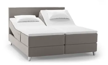 Ein verstellbares Svane® Zense Plus Bett in eleganter Ice Grey-Polsterung mit hochwertiger Matratze. Die getrennte Liegefläche ermöglicht individuelle Einstellungen für optimalen Schlafkomfort.