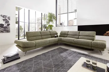 Großes grünes Ecksofa mit hohen Rückenlehnen.