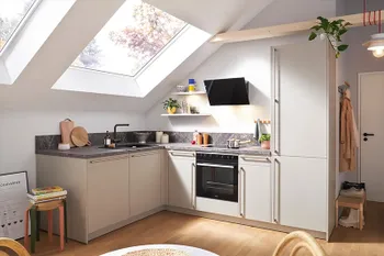 Moderne Eckküche mit hellgrauen Fronten in Dachgeschosswohnung.