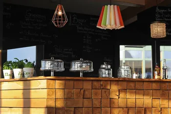 Theke mit Gläsern, Töpfen und Tortenplatten mit Hauben im Pavillon vor dem wöm