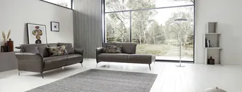 Braunes Ledersofa neben einem braunen Recamiere in einem hellen Raum.