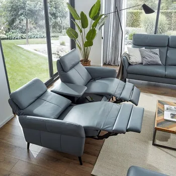 Blaues Sofa aus Leder, das auf beiden Seiten die Fußlehne ausgefahren und Rückenlehne nach hinten geklappt hat.