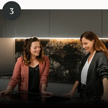 Nach fertig gestellter Planung stehen zwei Frauen zufrieden in einer Küche.