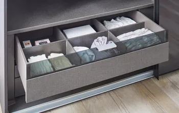 Geöffneter grauer Schubladen eines Kleiderschranks mit Fächer im Schubladen.
