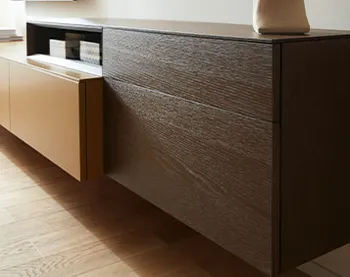 Hängendes Lowboard mit gelber Lackfront und dunklem Holz.
