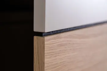 Ansicht der Türe eines Kleiderschranks, der im oberen Teil weiß ist und unten in Holzoptik.