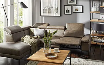 Olivgrünes Ledersofa mit komplett ausgezogener Fußstütze und klappbaren Kopfstützen.