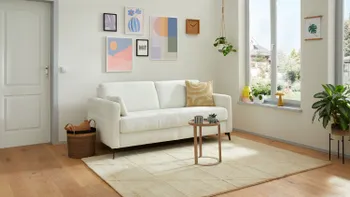 Weißes Zweisitzer Sofa in einem hellen Raum. 