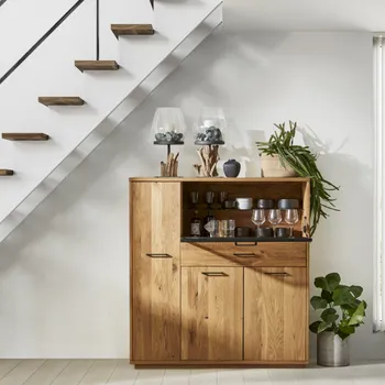 Highboard aus Massivholz mit schwarzen Griffen aus Metall mit geöffnetem Barfach, in dem Gläser stehen, auf dem Highboard stehen große Kerzengläser mit Holzdekoration.
