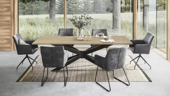 Sechs moderne graue Schalenstühle mit schwarzem Metallfuß um einen großen Esstisch aus Massivholz.