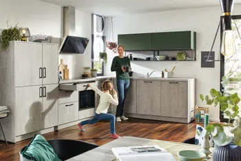Mutter mit Tochter in moderner L-Küche mit grauen und grünen Küchenfronten und offenem Essbereich.