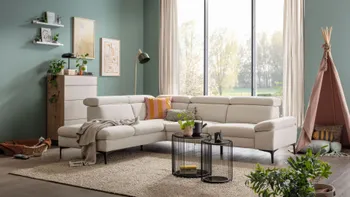Modernes beiges Ecksofa in einem gemütlichen Raum mit Kinderspielzeug.