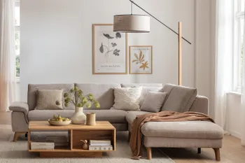 Graues Ecksofa in hellem gemütlichem Wohnzimmer mit Couchtisch aus Holz und moderner Stehlampe dahinter.