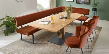 Hoelzerner Esstisch mit orangefarbener Sitzbank und passenden Stuehlen in Esszimmer.