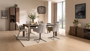 Gemütliches modernes Esszimmer mit dunklem Holzesstisch und grauen Schalenstühlen.