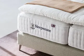 Boxspringbett mit beigem Stoffbezug und silbernen Füßen mit einer Sleepeezee Matratze
