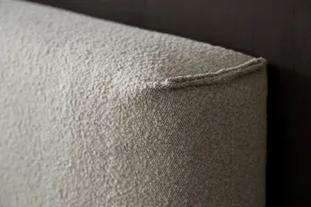 Detailansicht eines Kopfteils des Contur Boxspringbettes 4600 mit beigem Boucle bezogen.