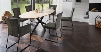 Modernes Esszimmer mit Holz Esstisch und Stühlen mit und ohne Armlehne in grauem Leder und schwarzem Metallgestell.