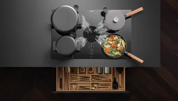 BORA Kochfeld mit Töpfen und Pfanne in moderner Küche mit schwarzem Design