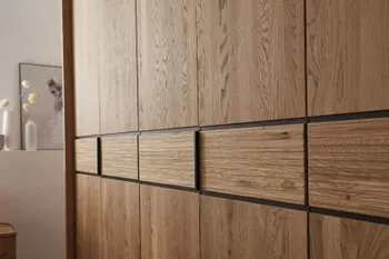 Massivholz Kleiderschrank mit fünf Türen und schwarzen Akzenten in der Mitte.