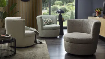 Drei moderne runde Sessel mit Boucle Stoff in den Farben Mint, Steingrau und Grün in einem modern eingerichteten Raum.