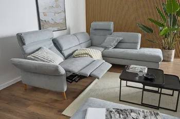 Graues Sofa aus Stoff mit ausgeklappter Relaxposition mit hellen Kissen und Decke.