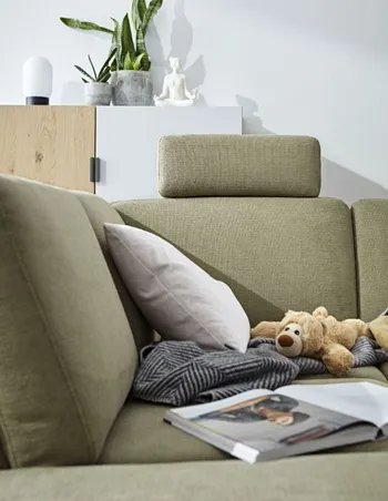 Sitzfläche eines grünen Sofas mit Kopfstütze.