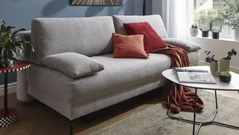 Graues Cord Sofa mit Schlaffunktion.