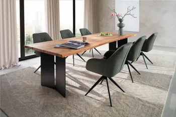 Moderne grüne Schalenstühle mit Armlehne und schwarzem Fußgestell um einen großen Massivholz Esstisch in einem hellen Raum.