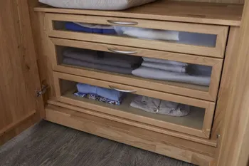 Drei Schubladen in einem Kleiderschrank, die aus Massivholz sind und Glas an der Front haben.