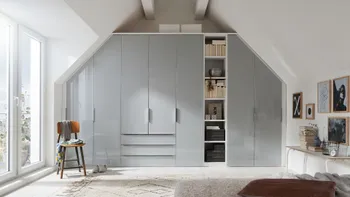 Passgenauer grauer Kleiderschrank in einem hellen Raum.