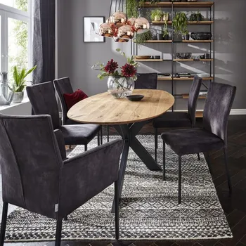 Esszimmer mit ovalem Esstisch aus Holz und Stühlen mit und ohne Armlehne in dunkellila Microfaserstoff.