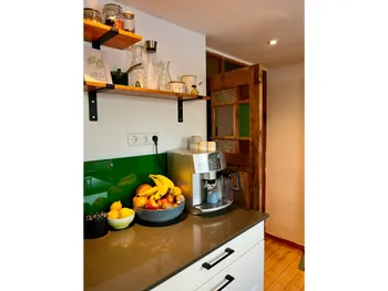 Moderne Arbeitsplatte mit Küchengeräten und frischem Obst.