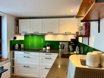 Weiße, moderne Küche mit dunkler Quarzstein-Arbeitsplatte