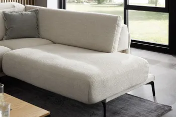 Beiges Sofa mit bequem gepolsterter Sitzfläche und silbernen Füßen.