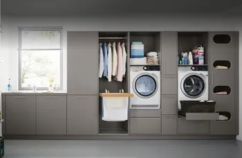 Hauswirtschaftsraum mit grauen Fronten, Waschmaschine und Lagerraum.
