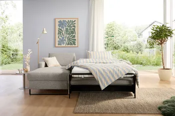 Ausgeklapptes Schlafsofa mit Kaltschaummatratze in modernem Wohnzimmer.