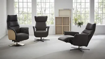 Drei schwarze Relaxsessel nebeneinander, der linke hat an der außenseite der Lehne Holzverkleidung, der rechte ist in Relaxposition.