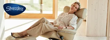 Frau entspannt in Stressless-Sessel vor heller Fensterfront