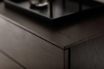 Detailansicht der Ecke einer modernen braunen Kommode.