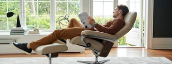 Stressless Relaxsessel Consul in beige mit Mann, der eine Zeitschrift liest