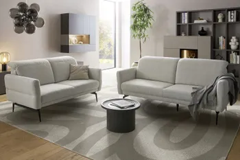Zwei Sofa Garnituren in creme mit schwarzem Metallgestell in einem hellen modernen Raum.