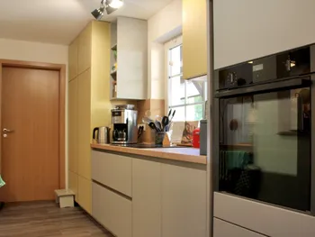 Gesamtansicht einer gelben, grifflosen Küche