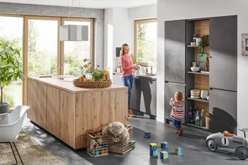 Frau mit Kind in kompakter Inselküche mit hölzerner Kücheninsel und anthrazitfarbenen Küchenfronten. 