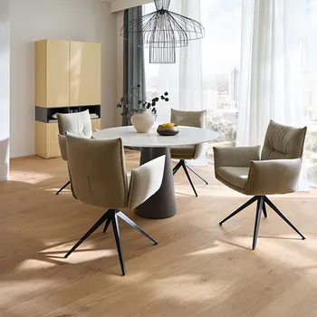 Elegantes Esszimmer mit rundem Esstisch und Armlehnstühlen in hellgrauem Leder.